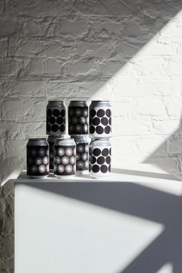 Stack of beverage cans with different black-and-white patterns